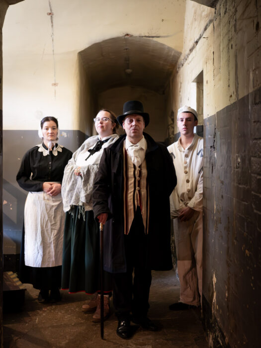 A victorian prison warden stands in the corridor of D Wing at Oxford Castle and Prison