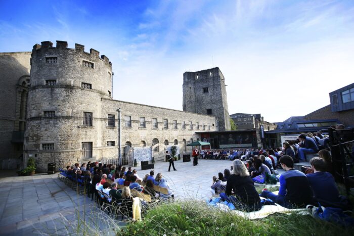 An exterior shot of the courtyard at Oxford Castle & Prison showing audiences enjoy The Oxford Shakespeare Festival