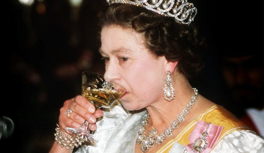 Queen Elizabeth drinks from a glass
