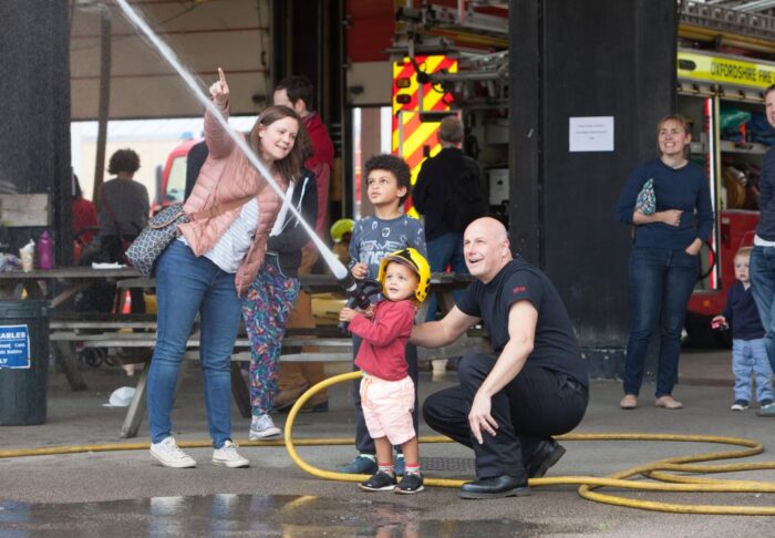 Children taking part of using the fire house under the watch of trained fire fighters.